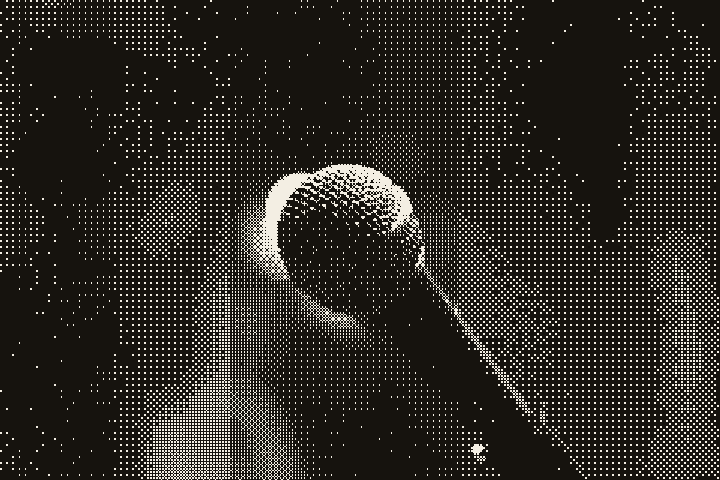 A microphone on a stand, no stage lights, nobody performing yet